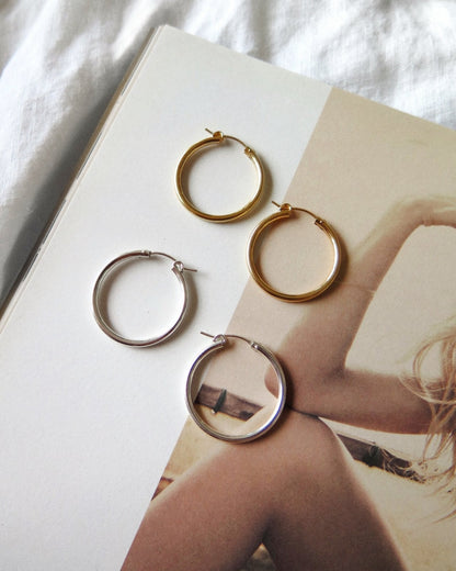 Medium Thick Hoop Earrings - Sterling Silver - 29mm hoops flat lay beside the 14k gold fill pair | The Littl